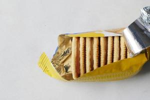 top view of sweet cookies in a plastic packet on wooden table photo