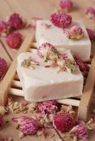 Homemade natural soap bar and dry flower on black background