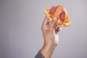 man hand picking slice of pizza against white background photo