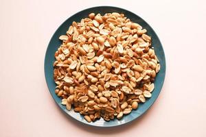 Processed pea nuts in a bowl on table top down . photo