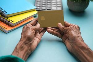 Cerca de las mujeres mayores mano sujetando la tarjeta de crédito