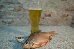 un vaso de cerveza ligera fresca con pescado seco foto