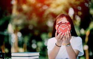 red alarm clock time management concept Female hands adjust or change the time on the clock to work. photo