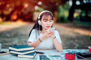 Listening to music. A beautiful woman with headphones is relaxing on her desk. smile and meditate meditation She is listening to music using her smartphone, chill and relaxation concept. photo
