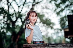 Young photographer. Happy holiday woman taking photos with Fleme camera and smiling.