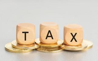 Cryptocurrency TAX concept. Coins and wooden blocks with text. Copy space photo