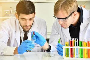 Two scientists have done a satisfactory experiment with the chemical samples in the lab. photo