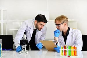 Two scientists have done a satisfactory experiment with the chemical samples in the lab. photo