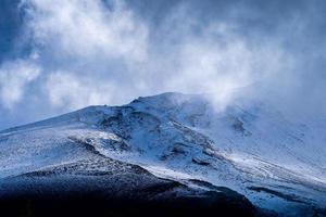 Close up top of Fuji mountain with snow cover and wind on the top with could in Japan. photo