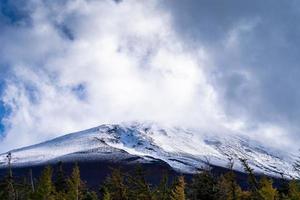 Close up top of Fuji mountain with snow cover and wind on the top with could in Japan. photo