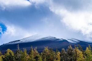 cierra la cima de la montaña fuji con cubierta de nieve y viento en la cima con podría en japón. foto