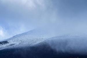 Close up top of Fuji mountain with snow cover and wind on the top with could in Japan.