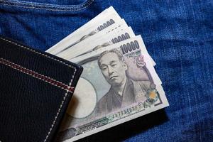 dinero japonés, billete de banco japonés, yen sobre fondo de jean. foto