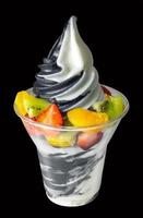 Yoghurt and charcoal soft serve ice cream with mixed fruits isolated. photo