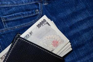 dinero japonés, billete de banco japonés, yen sobre fondo de jean. foto