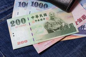 dinero taiwanés, billete de taiwán, dólar de taiwán sobre fondo de jean. foto