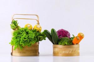 Assorted fresh organic vegetables in wicker basket isolated on white background. photo