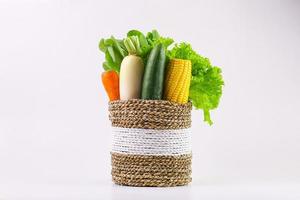 Assorted fresh organic vegetables in wicker basket isolated on white background. photo