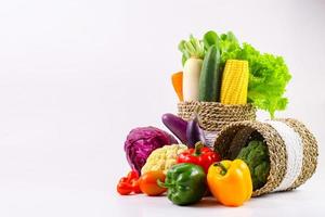 Assorted organic vegetables in wicker basket isolated on white background. photo