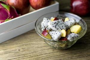 fruit salad in a bowl on the wooden table. Selective focus. photo