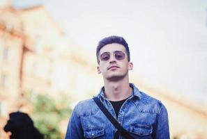 man in glasses posing in city photo