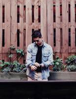 Young man in a trendy summer jacket in a stylish black t-shirt photo