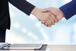 Close up 2 business people shaking hands during meeting in office room, partnership and cooperation concept photo