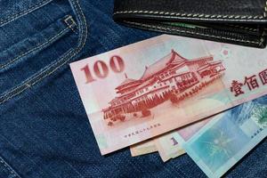 dinero taiwanés, billete de taiwán, dólar de taiwán sobre fondo de jean. foto