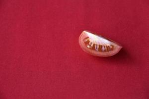 Juicy tomato on a red background photo