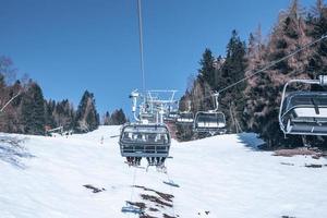 Skiers enjoying on ski lift over snowy mountain landscape