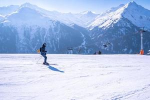 Skier in sportswear skiing on mountain against ski lift in cold weather