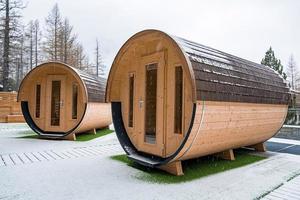 Wooden sauna houses on snow covered land during winter photo