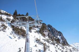 Cable car pulley on snow covered mountain slope photo