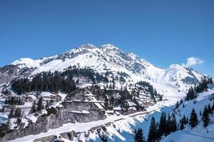 Avalanche barriers on snow covered mountain slope with trees photo