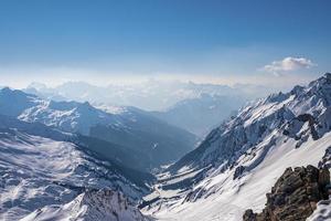 Idyllic snowy mountain range against sky in alps photo