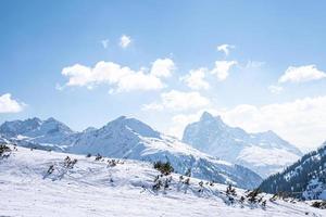 Ski tracks on snow covered mountain range slope photo