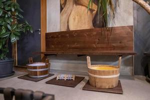 Wooden sauna buckets in spa center against oil painting hangs on wall photo