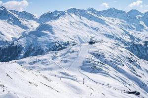 Aerial view of ski lift and skiers on snow covered hill slope photo