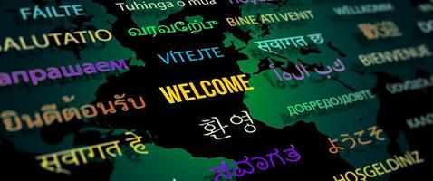 Welcome in different language with world map background.