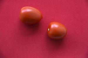 Juicy tomato on a red background photo