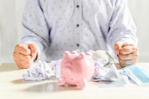 The businessman was very angry that his business went bankrupt. Concept for business failures caused by the coronavirus COVID-19 outbreak has forced many companies to close. piggy bank, financial photo