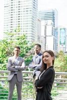 grupo de gente de negocios. gente de negocios reunida hablando y compartiendo sus ideas en la ciudad. equipo de negocios y concepto de trabajo en equipo. empresarios parados afuera en la ciudad discutiendo sobre un nuevo proyecto. foto