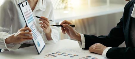 Group of business people meeting together Pointing to the graph assess business profits. photo