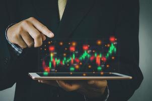 Finance and business investment concept. Stock and crypto investment funds.Businessman analyzing or trading Forex graphs of financial data candlestick chart. photo