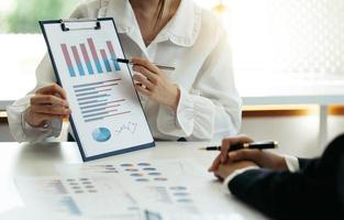 Group of business people meeting together Pointing to the graph assess business profits. photo