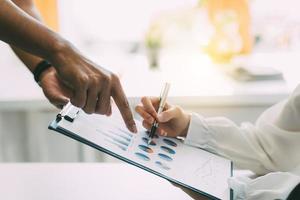 Group of business people meeting together Pointing to the graph assess business profits. photo