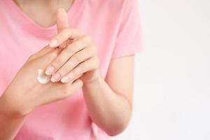 Women apply moisturizer on their hands to keep their skin healthy with white background. Body skin care concept.