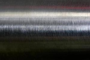 textura de reflexión sobre tubería de acero inoxidable en cuarto oscuro, fondo abstracto foto