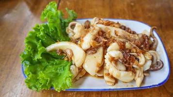 Stir fried squid with crispy garlic and pepper, Pla Muek Tod Gra Tium. photo