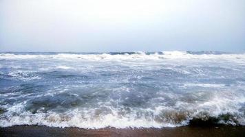 ola del mar en la playa de arena foto
